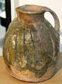 Red earthenware jug with copper stained glaze made at Audlem, Cheshire at Potteries Museum & Art Gallery. Hanley, Stoke-on-Trent, England.