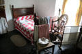 Spinning wheel beside bed with quilt in Ballydugan Weaver's house at Ulster Folk Park. Belfast, Northern Ireland.