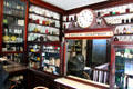 Pharmacy dispensing department with clock in J Hill Chemist shop at Ulster American Folk Park. Omagh, Northern Ireland.