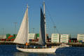 Sailboat passes containers in Port of Los Angeles. San Pedro, CA.