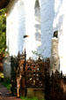 Mission Dolores chapel outer adobe wall & cemetery tombstones & cast iron fences. San Francisco, CA.