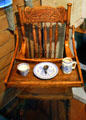 Antique wooden high chair with child's dishes at Mariposa Museum. Mariposa, CA.