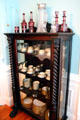 Glass display case with porcelain dinner service in dining room at Pardee Home Museum. Oakland, CA.
