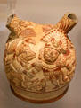 Moche ceramic stirrup-spout bottle figure of Wrinkle Face being held by arms by supernatural bird from Peru at Dumbarton Oaks Museum. Washington, DC.