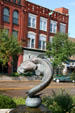 Sculpture of swimming catfish & building with deer head. Clinton, IA.