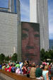 Crown Fountain tower in Millennium Park seen against surrounding skyscrapers. Chicago, IL.