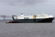 Ocean freighter entering Baltimore harbor with tugboat. Baltimore, MD.
