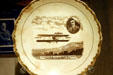Souvenir plate of Glenn Curtiss & his aeroplane over Hammondsport, NY by Carnation/McNicol of East Liverpool, OH at Henry Ford Museum. Dearborn, MI.