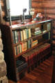 Arts & Crafts book case by Craftsman Workshops of Eastwood, NY & objects including candle stick telephone at Stickley Museum at Craftsman Farms. Morris Plains, NJ.