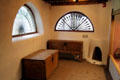 Room with chests, fireplace & semiround windows at Millicent Rogers Museum. Taos, NM.