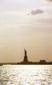 Statue of Liberty in light of setting sun. New York, NY.