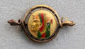 Egyptian revival gold & enamel brooch with pharaoh profile held by snakes from Newark, NY at Metropolitan Museum of Art. New York, NY.