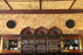 Cork-tile ceiling & wall, spool-work roundels over built in walnut buffet with spindle screen by Stanford White in Dining Room at Kingscote. Newport, RI.