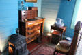 Bedroom with desk & cast iron stove in Yates House at Sam Houston Park. Houston, TX.