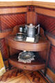 Corner étagère with metal water pitcher & basket tray at Capt. Charles Schreiner Mansion. Kerrville, TX.