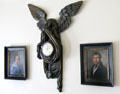 Pine carved eagle with clock imbedded & bearing the name of the clockmaker Joseph Neeg of Munich framed by portraits of Wilhelm & Caroline Trundt Brueckish at Museum of Texas Handmade Furniture. New Braunfels, TX.