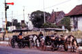 Horse-drawn carriage taxies wait outside rail station. Jogyakarta, Indonesia.